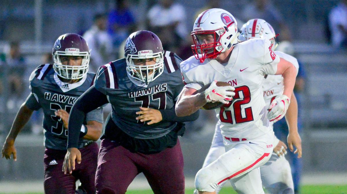 Ripon running back Grant Wiebe (22) is pursued by two Central Valley defenders during a game between Ripon High School and Central Valley High School at Ceres High School in Ceres California on September 6, 2019.