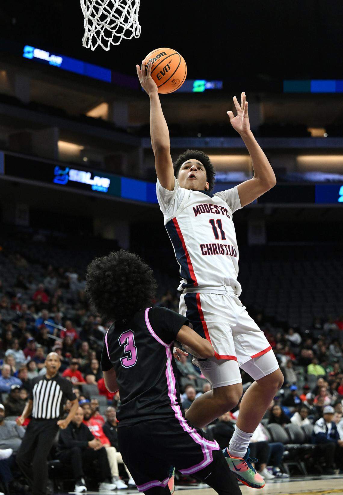 Modesto Christian’s Gavin Sykes draws a foul from Lincoln’s Eliah Holmes during Sac-Joaquin Section Division I championship game at the Golden 1 Center in Sacramento, Calif., Wednesday, Feb. 21, 2024.