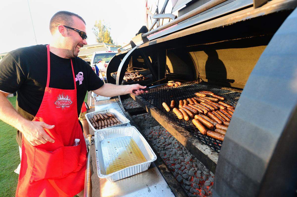 Modesto firefighters cook bratwurst at a past year’s Oktoberfest held at John Thurman Field.