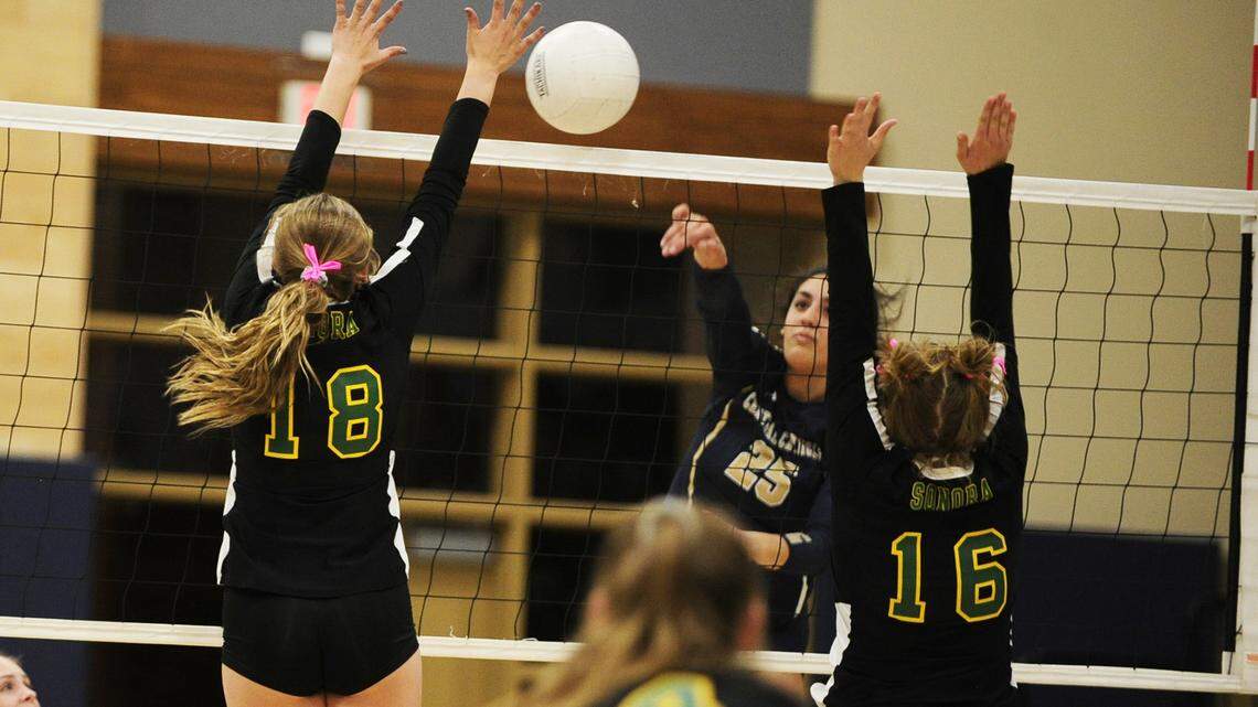 Abby Castillon threads the needle through two Sonora blockers, during a playoff game between Sonora and Central Catholic, in Modesto, on Thursday, October 31.