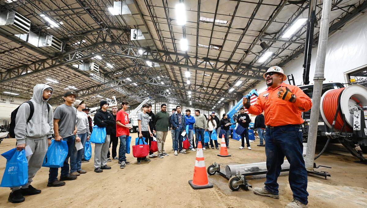 City of Modesto utilities services worker Nasson Sanchez speaks to a group of high school students during Construction Trades Day at the Modesto Junior College West Campus in Modesto, Calif., Wednesday Nov. 15, 2023. The event was organized by the Valley Builders Exchange, a Modesto-based group that helps contractors with hiring and training.