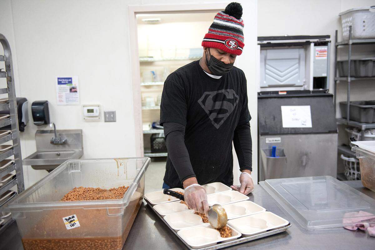 Bryan Nunley works filling food trays at Howard Prep in Ceres, Calif., Wednesday, Feb. 21, 2023.