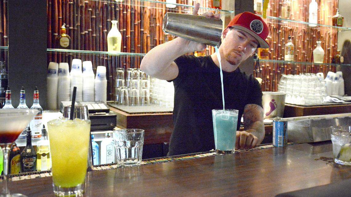 Tiki Cocktail Lounge bartender Dillen Sweeten serves up a variety of mixed drinks at the long-running McHenry Avenue bar.