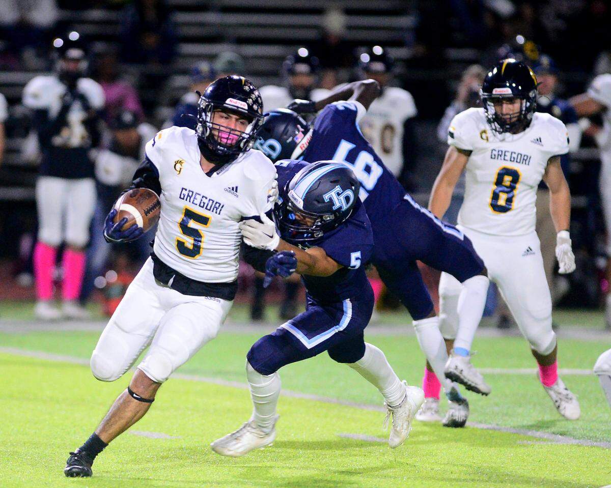 Gregori’s Landon Gutierrez (5) tries to sprint around a Downey defender during a game between Downey and Gregori at Downey High School in Modesto, California on October 27, 2023.