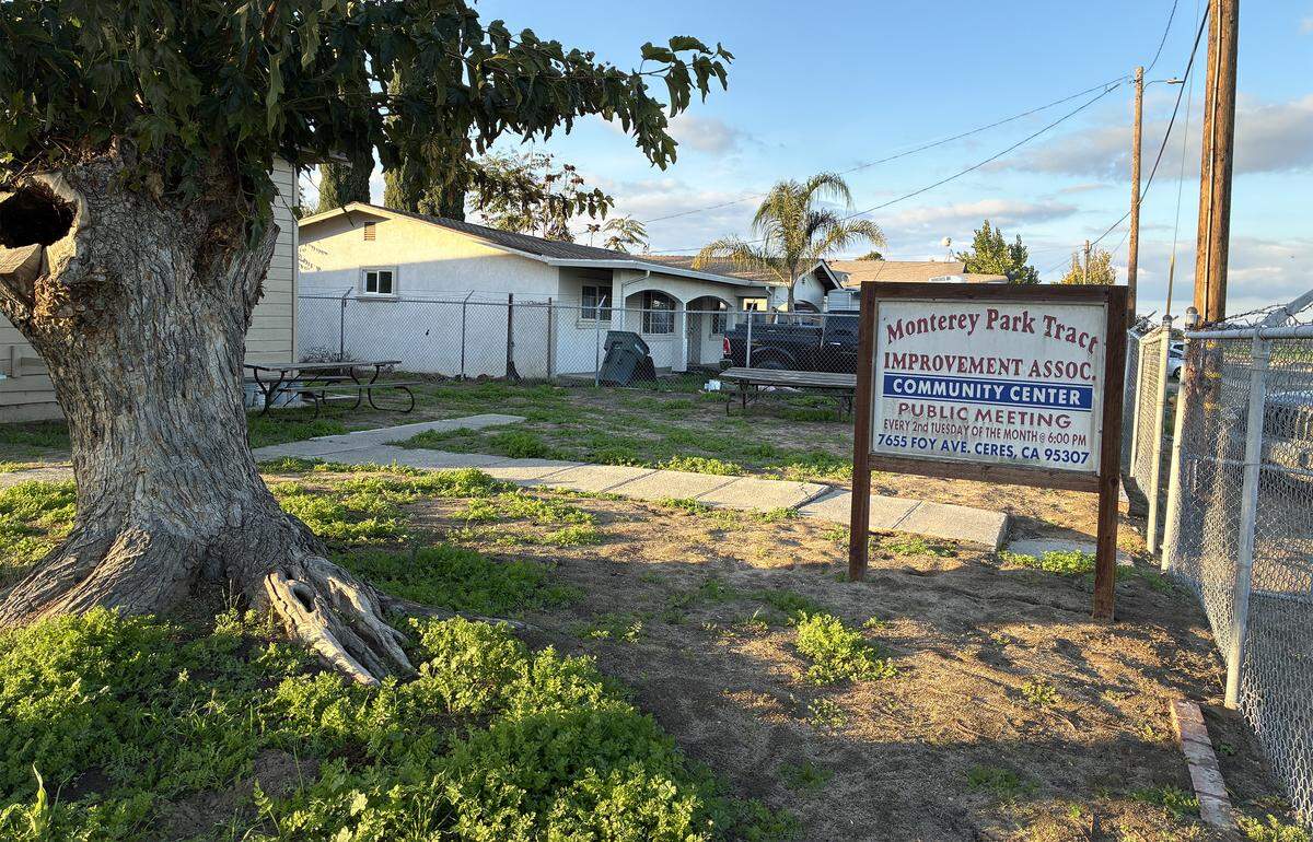 A sign that reads “Monterey Park Tract Improvement Association Community Center, public meeting every second Tuesday of the month at 6 p.m.” near a tree outside a community center at around 4 p.m.