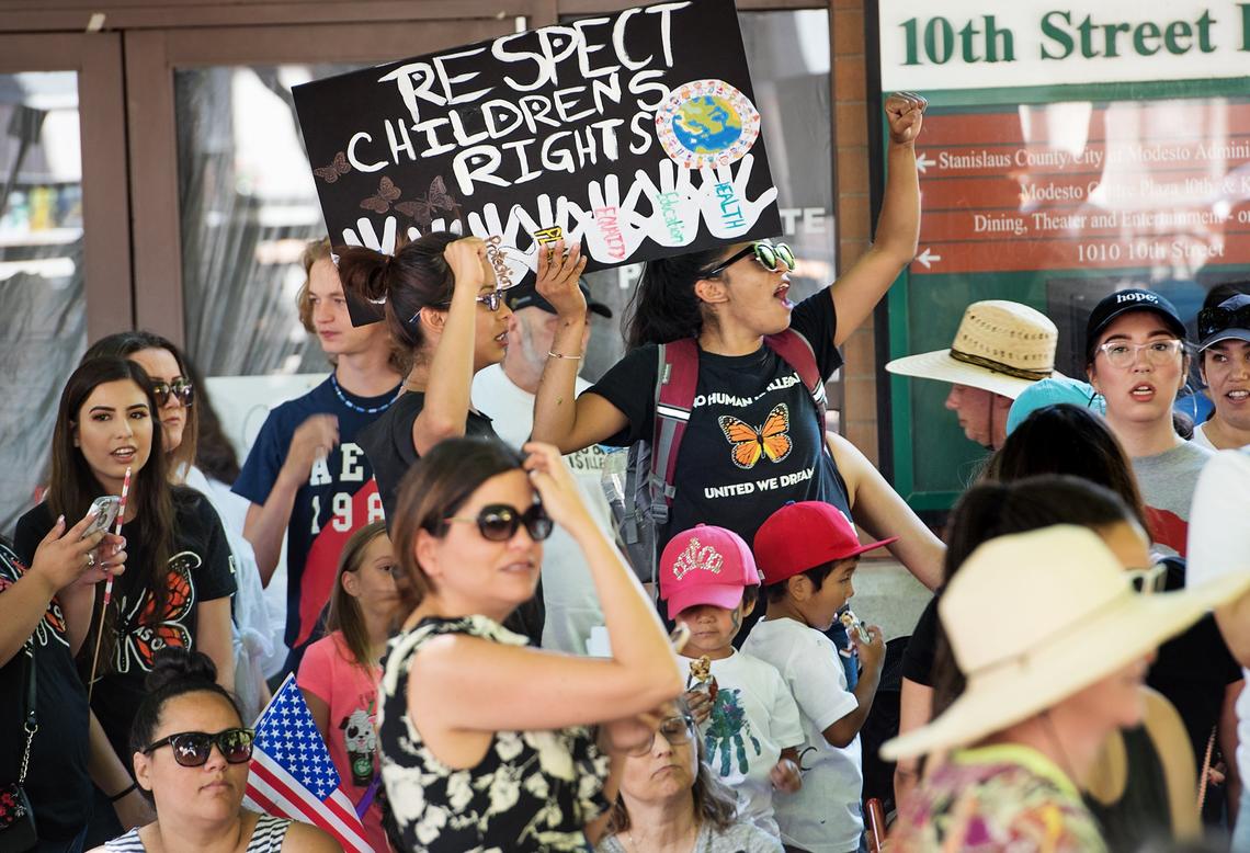 Ruby Figueroa, middle top, and others rally outside 10th Street Plaza during the Families Belong Together protest in Modesto, Calif., Saturday, June 30, 2018.