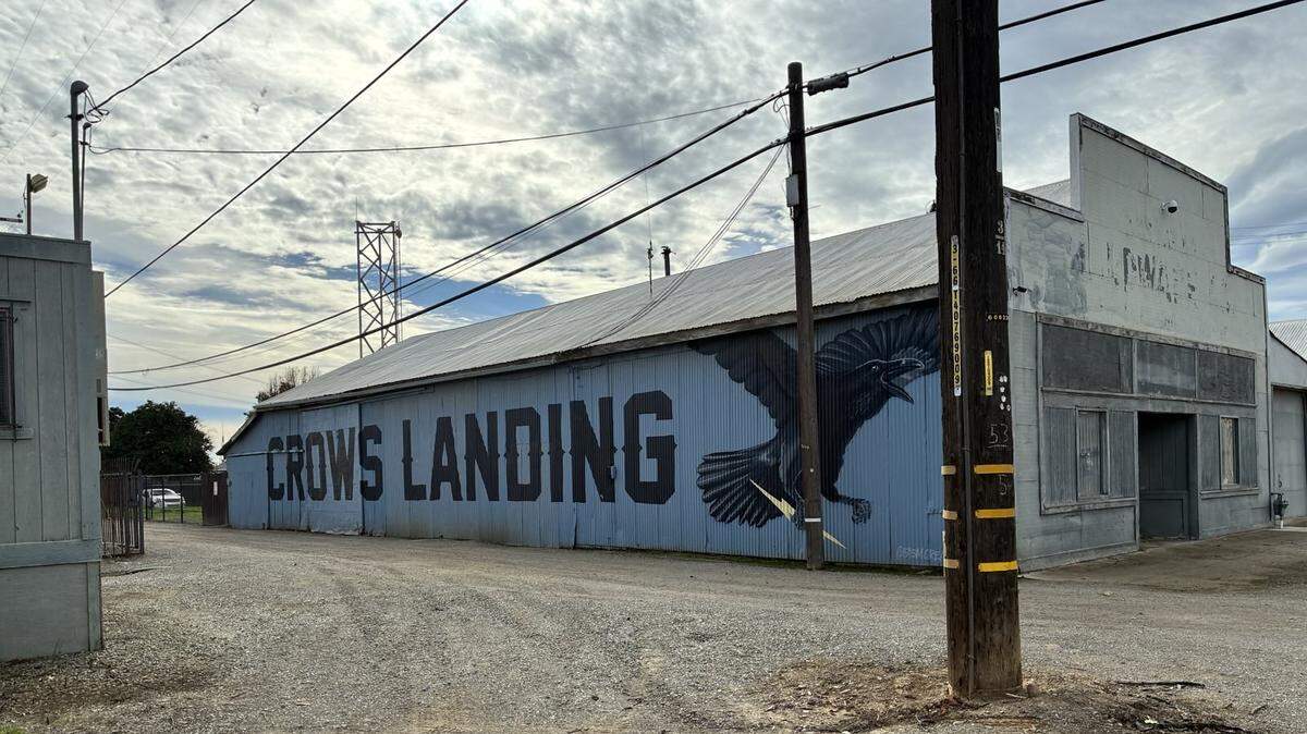 A mural that reads “Crows Landing” with a painted crow alongside an abandoned building.