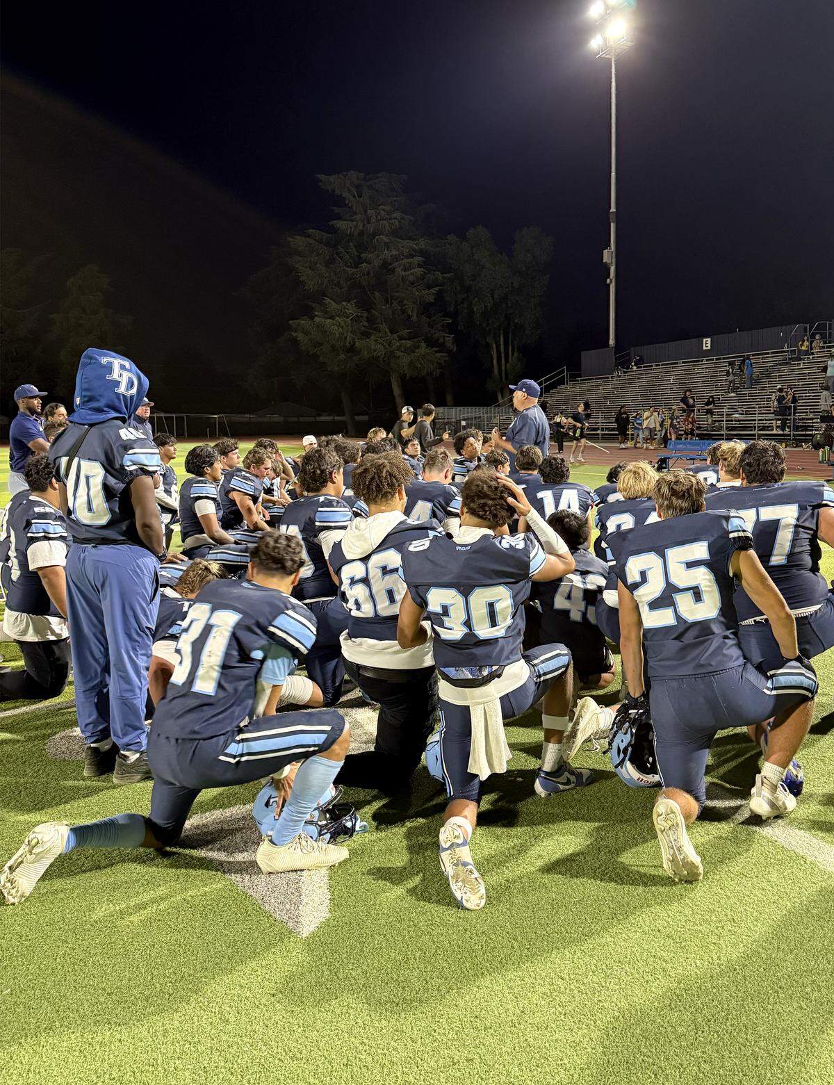 Downey coaches talk with players after the game with Merced at Downey High School in Modesto, Friday, Sept. 5, 2025.