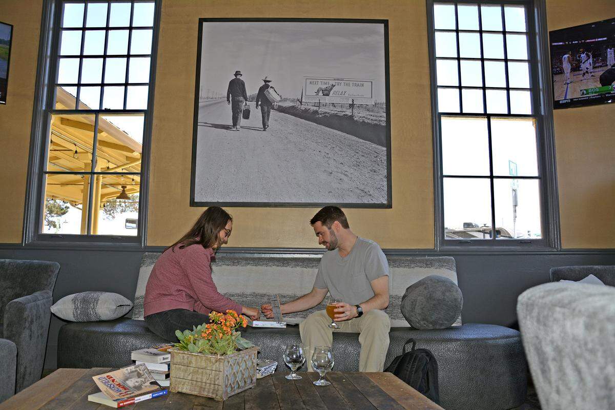 Hanna and Chris Ewbank of Pacific Grove play a board game while drinking beer in the new Dust Bowl Brewing Co. taproom in Monterey, Calif. on July 6, 2019. 