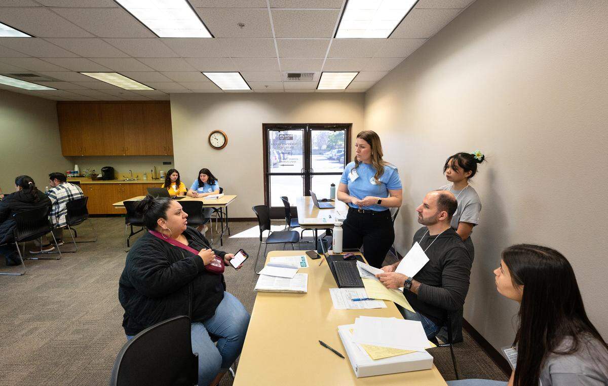 Downey business teacher Tera Coleman, her students, and United Way CEO Keristofer Seryani, seated, help Crystal Gonzalez, left, file her tax return as part of the Volunteer Income Tax Assistance program (VITA) at the United Way office in Modesto, Calif., Saturday, March 16, 2024.