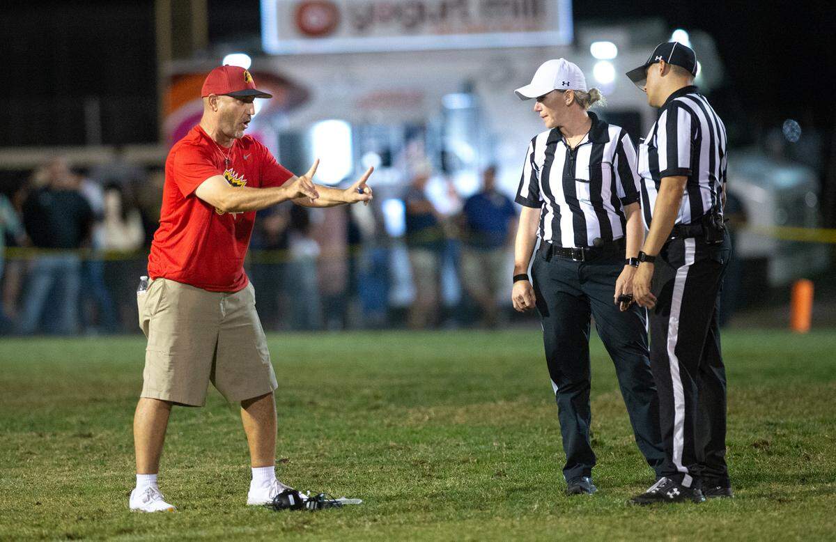 Oakdale head coach Trent Merzon talks with officials during the Valley Oak League game with Central Catholic in Modesto, Calif., Friday, Oct. 14, 2022.