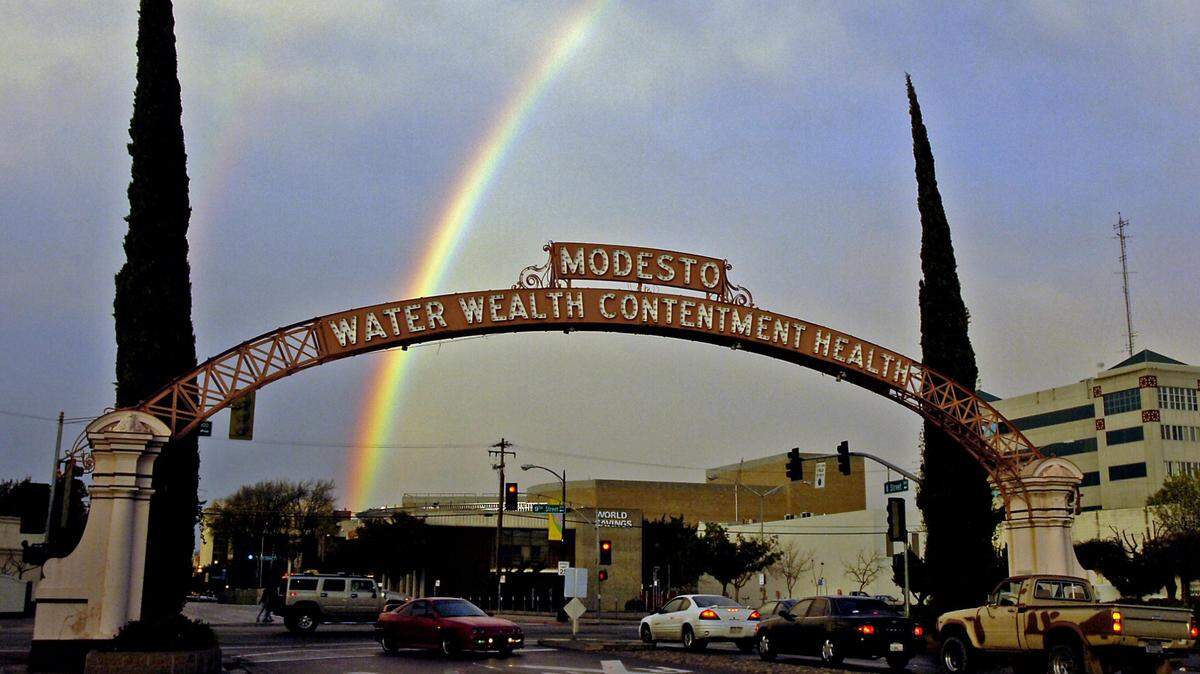 A rainbow appears alongside the Modesto Arch on Friday, April 7, 2006.