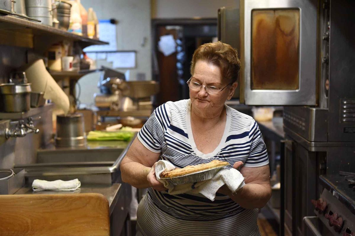 Piemaker Paula Loomis takes a pie out of the oven at Latif’s in Turlock, Calif. on Wednesday November 20, 2019.