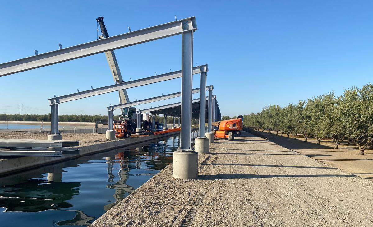 Workers assemble a solar panel array over a Turlock Irrigation District canal Ceres.
