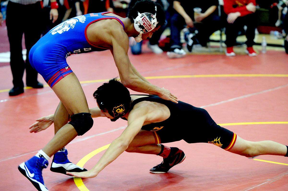 Oakdale wrestler Brandon Abell, right, shoots for the legs of Durham wrestler Yousuf Zigan, on Saturday, December 9, during the James Riddle Memorial Wrestling Tournament at Oakdale High School.