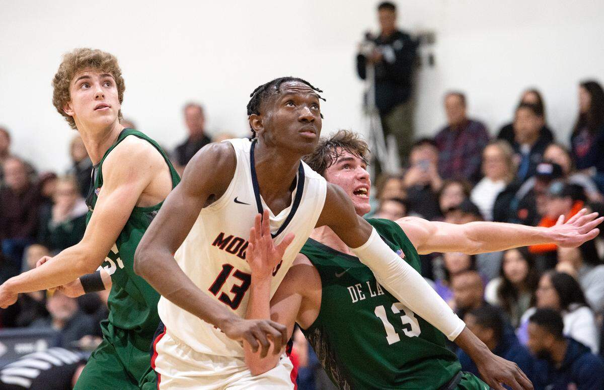 Modesto Christian’s Prince Oseya, middle, and De La Salle’s Evan Wells prepare for a rebound during the NorCal Open Division semifinal playoff game in Salida, Calif., Saturday, March 4, 2023.