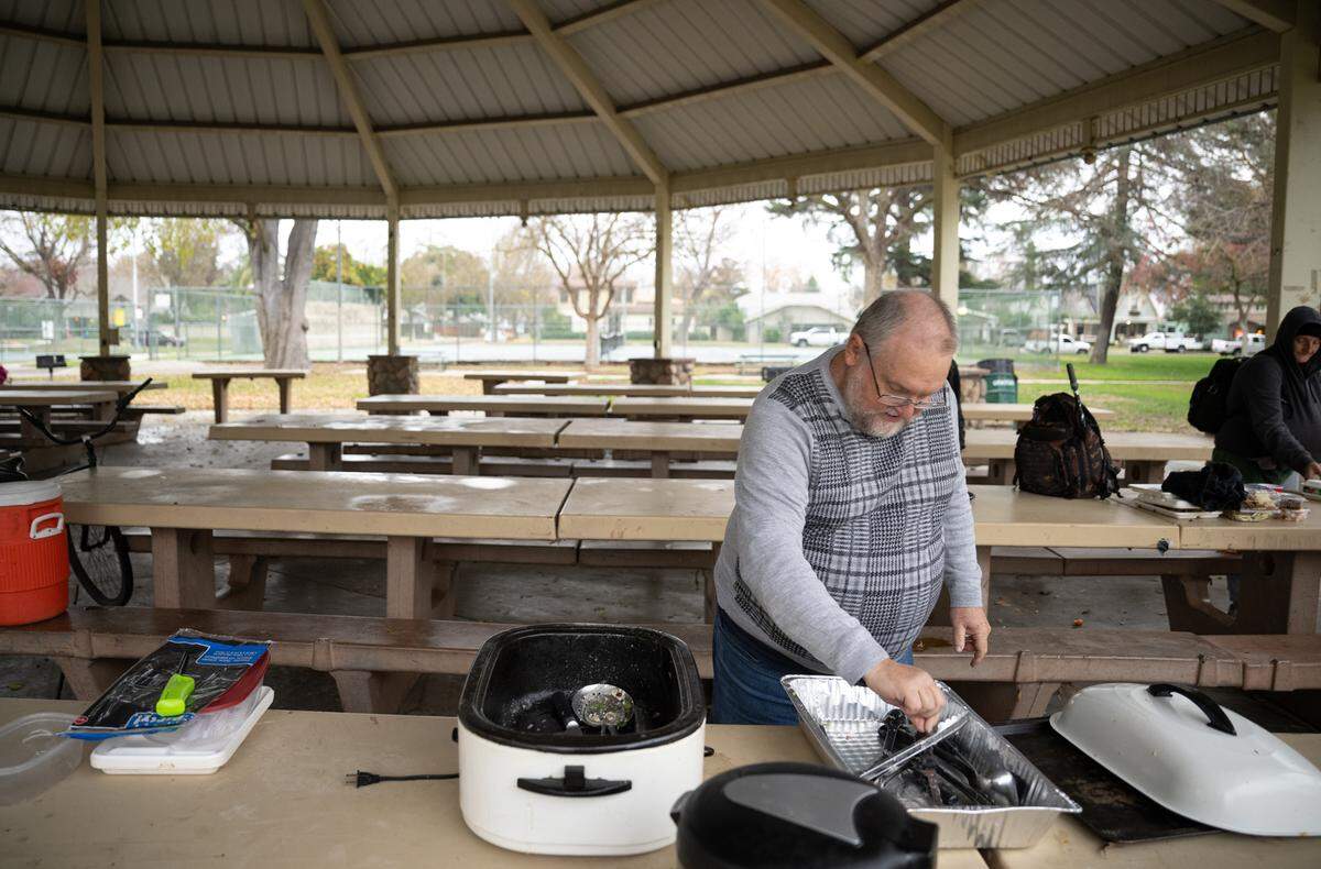 Daniel Lempenau, aka Pastor Dan, cleans up after a picnic at Graceada Park in Modesto on Friday, Dec. 13, 2024. Lempenau organized a picnic in memory of his friend Carl Wolden.