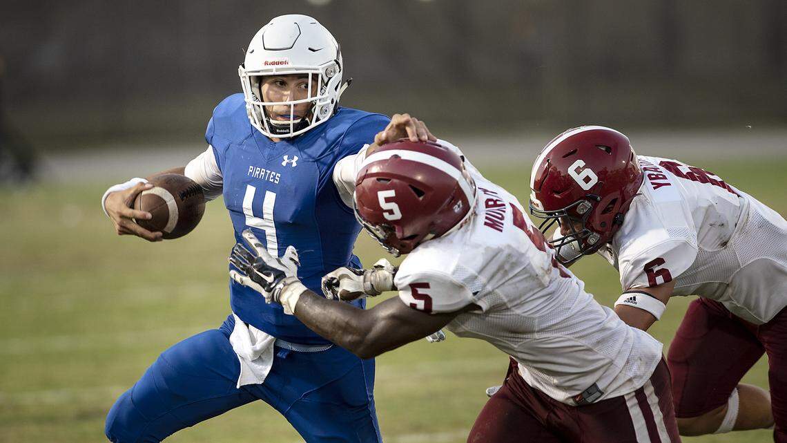Modesto quarterback Danny Velasquez fights off Sierra defenders Amir Murray and Tyson Ybarra at Modesto Junior College in Modesto, Calif., Saturday, Sept. 14, 2019. MJC won the game 50-20.
