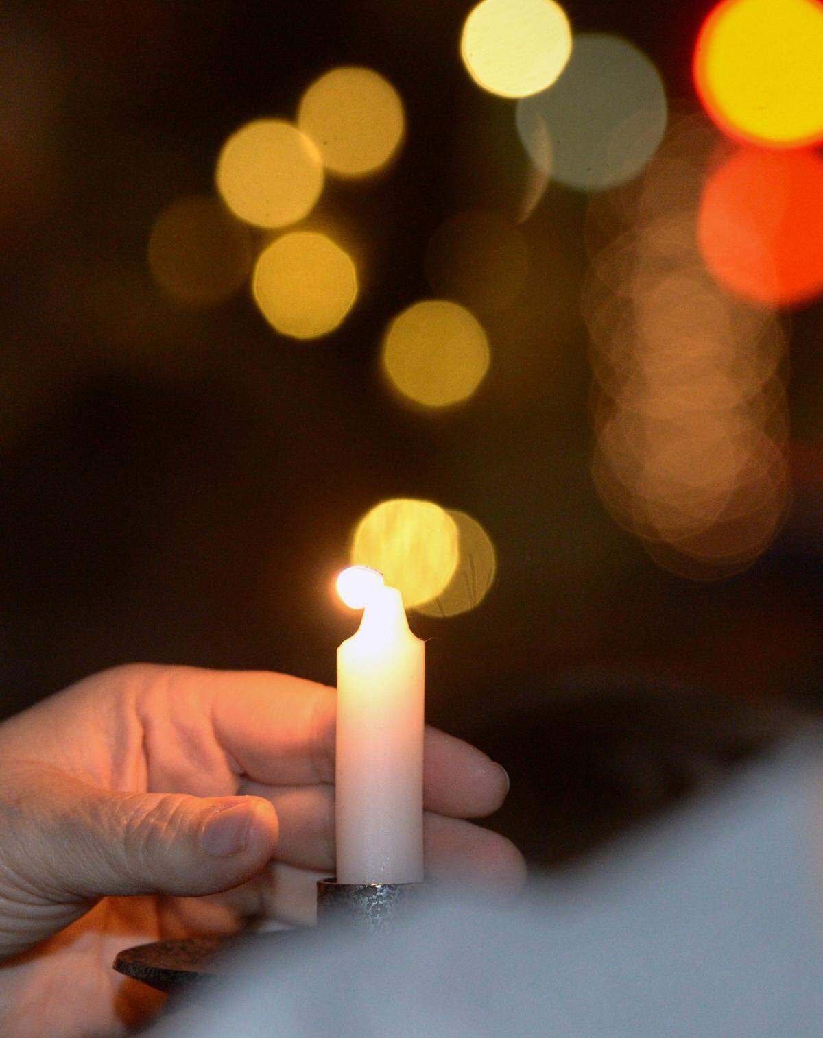 A candle is placed during a past year’s menorah lighting held by Congregation Beth Shalom at Tenth Street Plaza.
