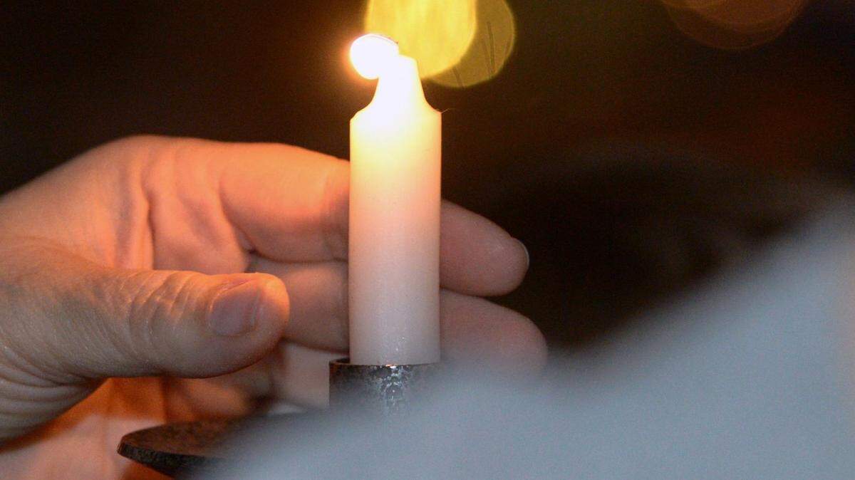 A candle is placed during a past year’s menorah lighting held by Congregation Beth Shalom at Tenth Street Plaza.