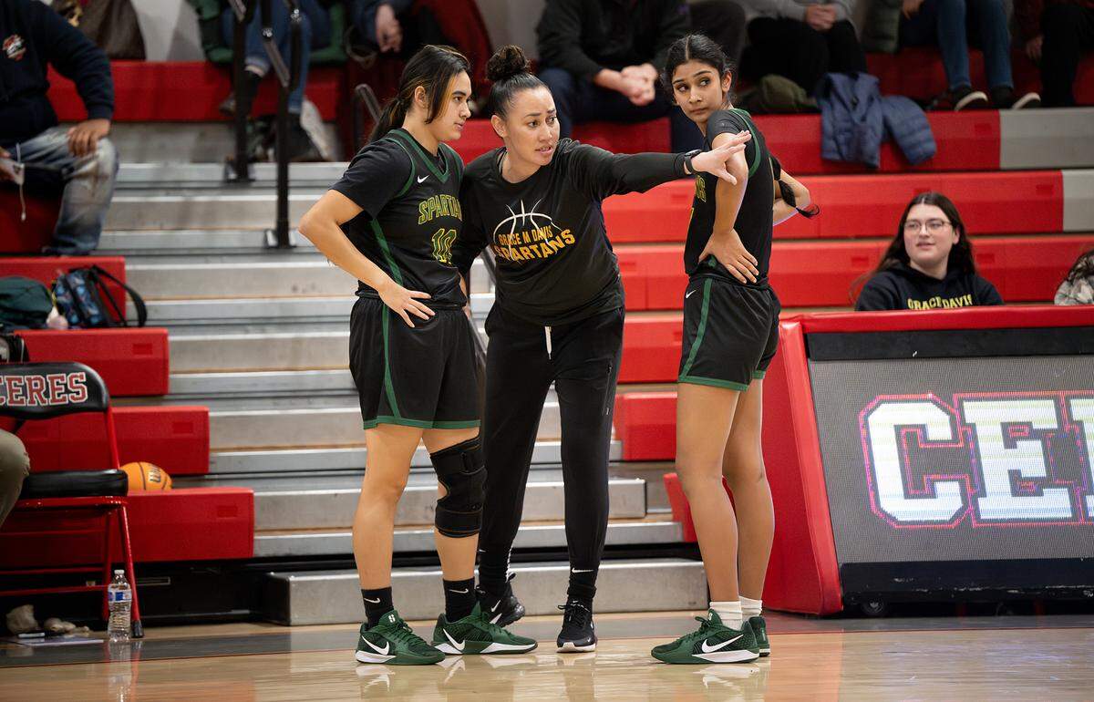 Grace Davis’ coach Tracy Cole huddles with players Maria Nuno, left, and Nima Kaur, right, in the Western Athletic Conference game with Ceres at Ceres High School in Ceres, Thursday, Jan. 16, 2025.