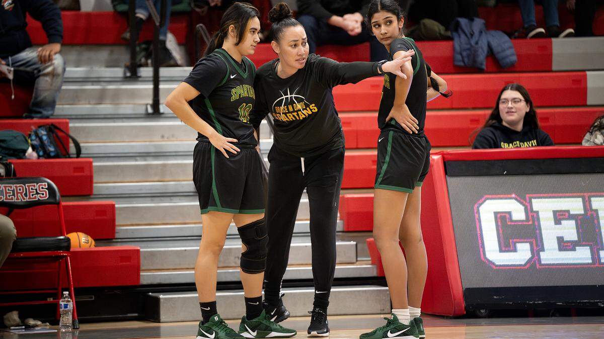 Grace Davis’ coach Tracy Cole huddles with players Maria Nuno, left, and Nima Kaur, right, in the Western Athletic Conference game with Ceres at Ceres High School in Ceres, Thursday, Jan. 16, 2025.