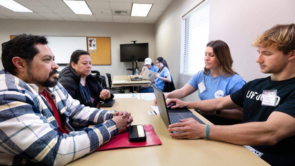 Downey senior Sage Verschelden, right, helps Alejandro Velasco and Arcelia Flores, left, file taxes as part of the Volunteer Income Tax Assistance program (VITA) at the United Way office in Modesto, Calif., Saturday, March 16, 2024.