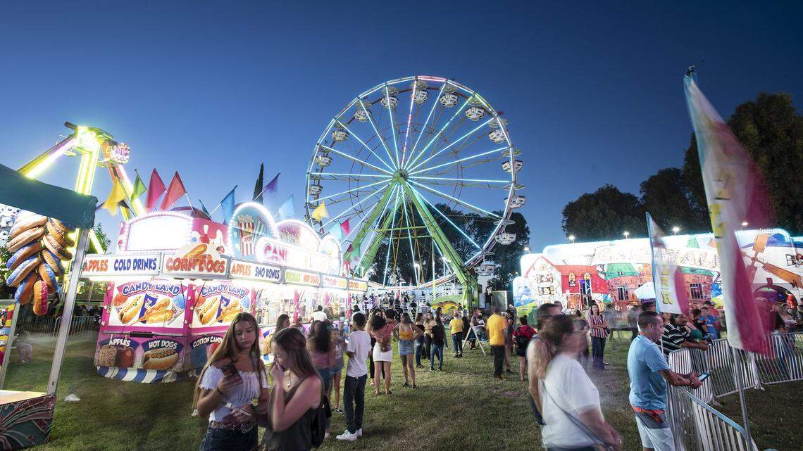 People are pictured on the midway on opening day at the Stanislaus County Fair in Turlock, Calif., Friday, July 12, 2019.