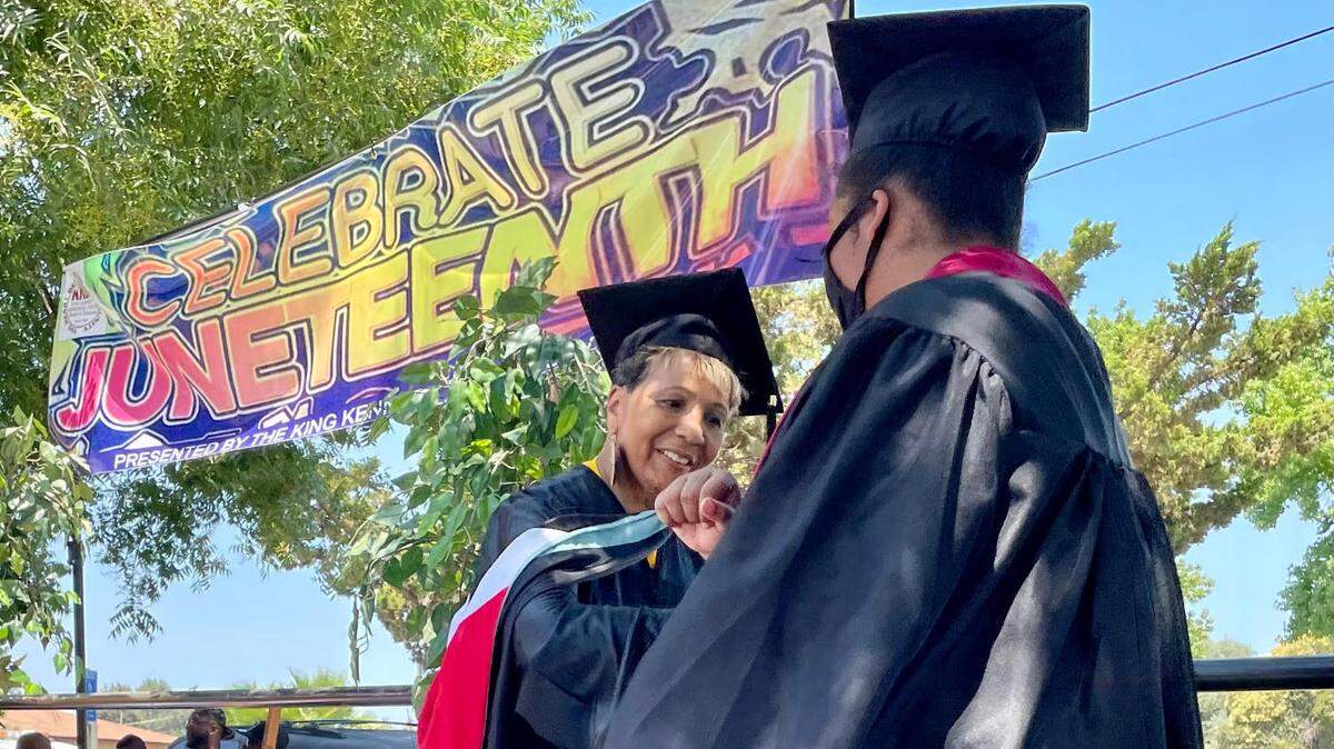 Wendy Byrd, president of the Modesto/Stanislaus chapter of the NAACP, elbow bumps at 2021 graduate during a ceremony at Modesto’s Juneteenth celebration at Martin Luther King Jr. Park on Saturday, June 19, 2021.