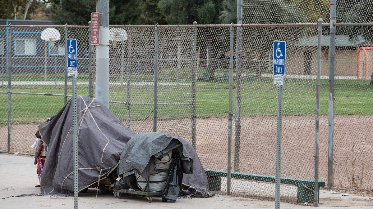 Belongings of a homeless resident are neatly packed up by the baseball field at Mellis Park in Modesto, Calif., on Wednesday, Oct. 20, 2021.