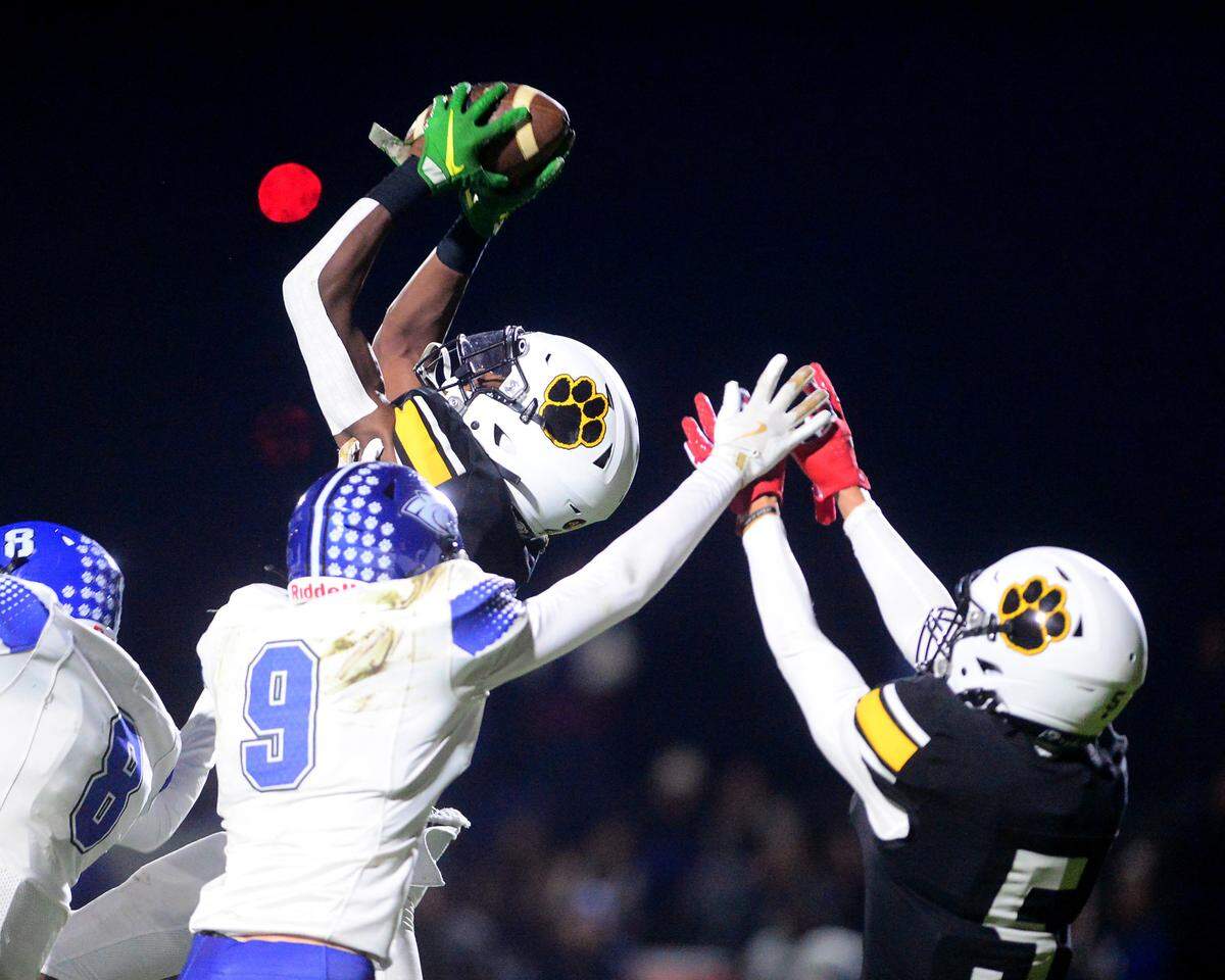 Hughson receiver Malakai Sumter (4) leaps over multiple defenders to make a catch during a 2024 CIF Sac-Joaquin Section Division V Playoff game between Hughson High School and El Dorado High School at Hughson High School in Hughson California on November 15, 2024. Hughson won the game 28-6.