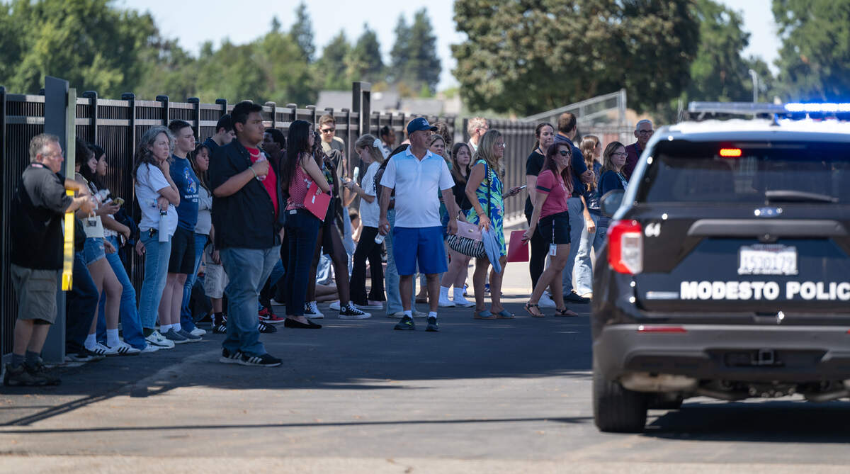 Students and staff watch as Stanislaus County Sheriff’s Department bomb squad investigate a bomb threat at Beyer High School in Modesto, Calif., Thursday, Aug. 15, 2024.