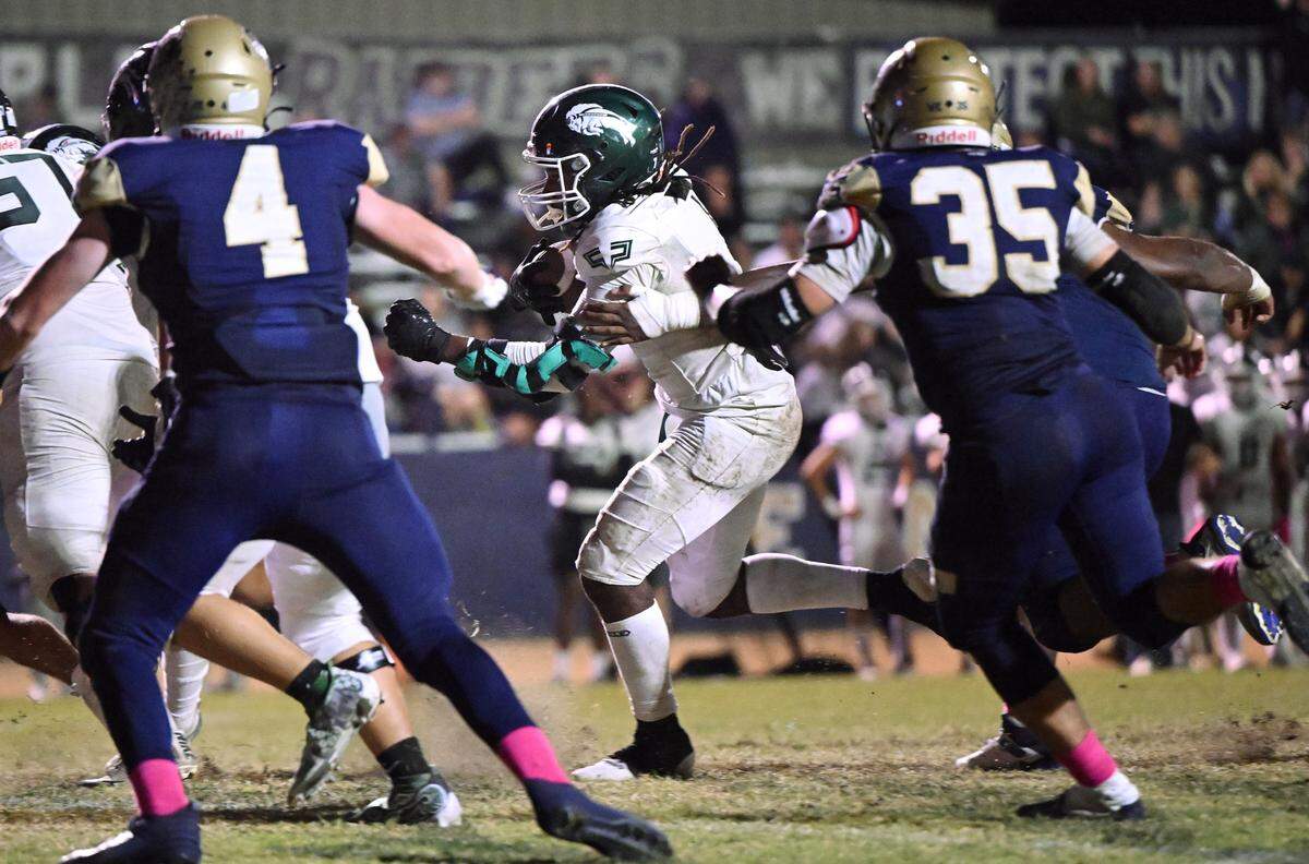 Manteca’s Bryson Davis runs for a touchdown past Central Catholic defenders during the Valley Oak League game at Central Catholic High School in Modesto, Calif., Friday, Oct. 20, 2023.