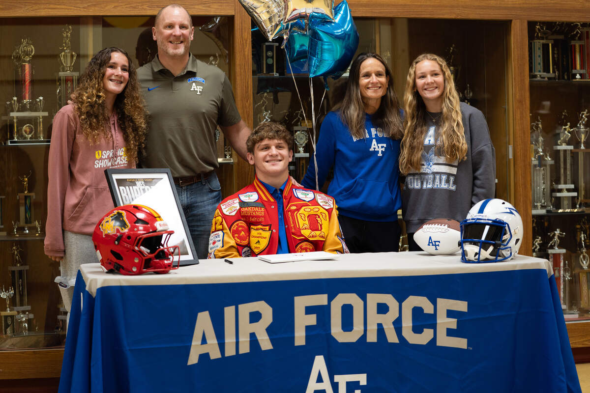 Oakdale High School football player Wes Burford takes a picture with his family after signing with Air Force on National Signing Day in Oakdale, Calif. on Wednesday, Dec. 3, 2025.