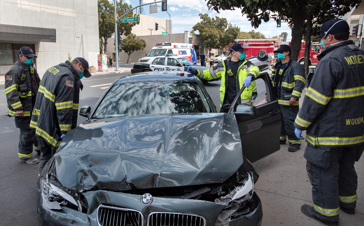Bomberos de Modesto atienden una colisión de tráfico en J Street, en el centro de Modesto, California, el viernes 14 de agosto de 2020.