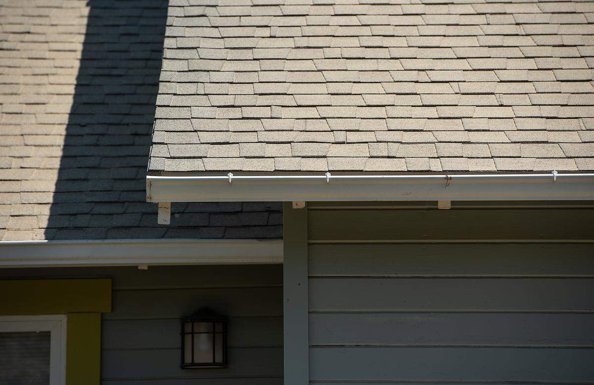 Fine dust from a Sierra Northern Railway and Central Valley Ag Group grain transfer station has settled on the roof of a house adjacent to the operation just east of Oakdale, Calif., on Thursday, July 8, 2021.