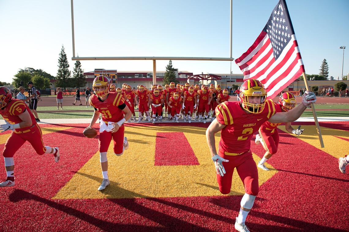 Oakdale seniors Caleb Kuppens (2) and Hayden Knittel, (11) lead their teammates on the field before the start of the non-conference league game with Sonora in Oakdale, Calif., Friday, August 17, 2018.