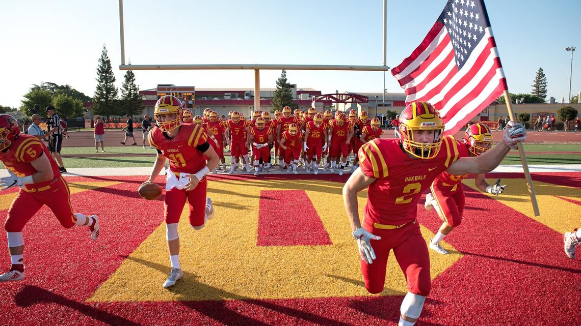 Oakdale seniors Caleb Kuppens (2) and Hayden Knittel, (11) lead their teammates on the field before the start of the non-conference league game with Sonora in Oakdale, Calif., Friday, August 17, 2018.