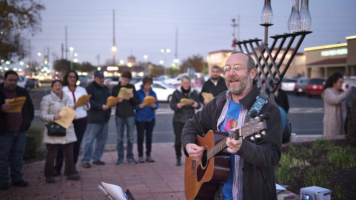 Congregation Beth Shalom Rabbi Shalom Bochner leads a group in songs during a past year’s Hanukkah menorah lighting at McHenry Village in Modesto.