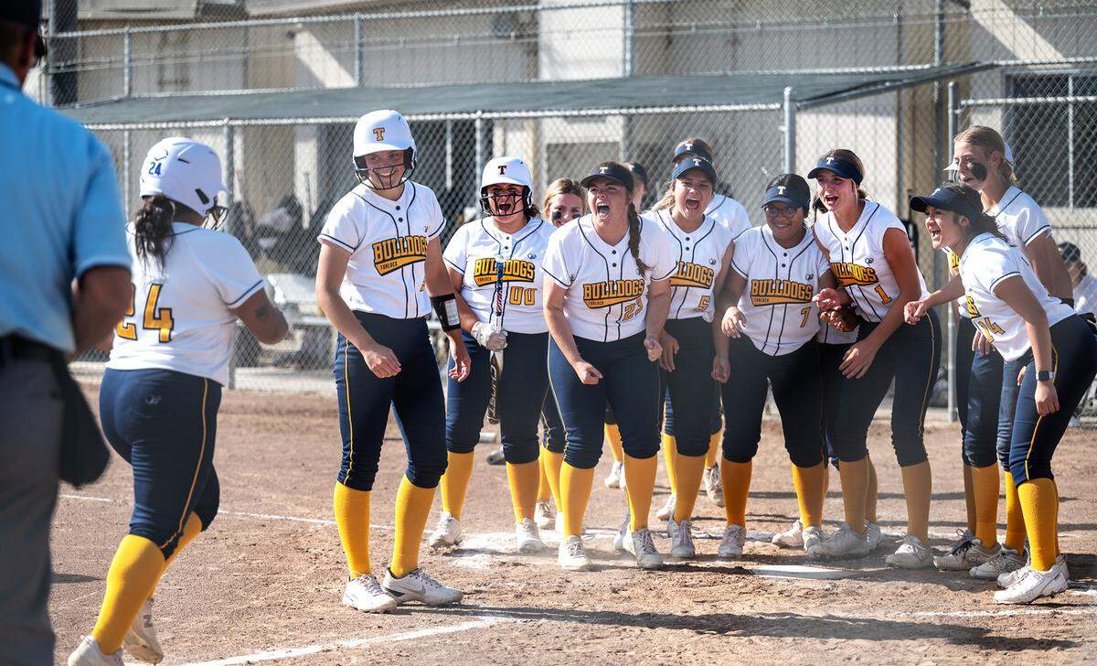 Turlock players celebrate the home run by Angie Valenzuela (24) during the Central California Athletic League game with Pitman at Turlock High School in Turlock, Calif., on Thursday, April 7, 2022. Turlock won the game 8-2.