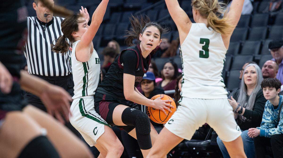 Riverbank’s Livi Fernandez looks to pass under pressure from Colfax defenders Maycee Heimann (3) and Jade Biittner during the Sac-Joaquin Section Division IV championship game at Golden 1 Center in Sacramento, Calif., Friday, Feb. 24, 2023. Colfax won the game 56-38.