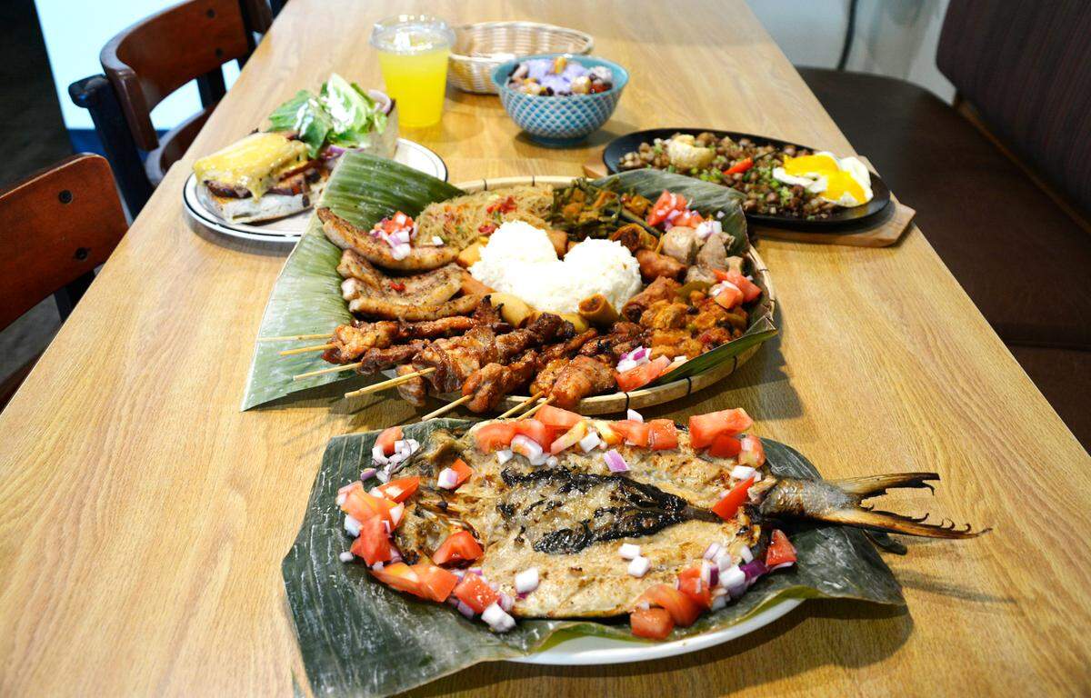 Some of the offerings at the new Filipino restaurant Kusina including from front: whole monkfish, a family platter with skewers, sisig (right), pork belly sandwich (left) and halo halo.