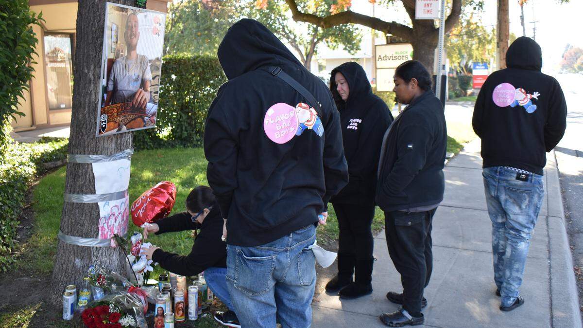 The mother of 23-year-old Bryan Luque, who was fatally shot Friday night on the 1500 block of Coffee Road in Modesto, joins other family members Tuesday at a memorial created near where he died. Bryan’s mother, Candace Jackson, is pictured center.