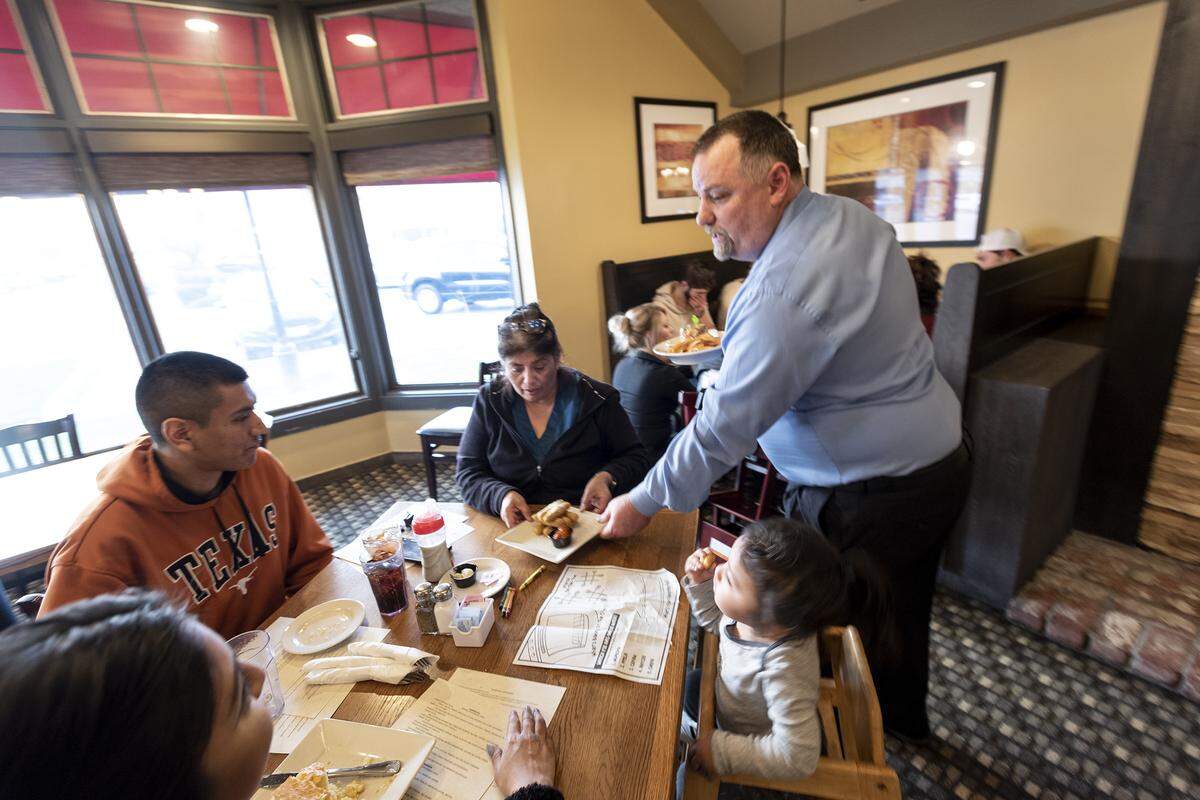 District General Manager Tony Schroeder serves Diana Sainz and her family members Martin and Angelica Ramos, left, during a training service in preparation for the reopening of the Marie Callendar’s Restaurant in Modesto, Calif., on Wednesday, Jan. 8, 2020.