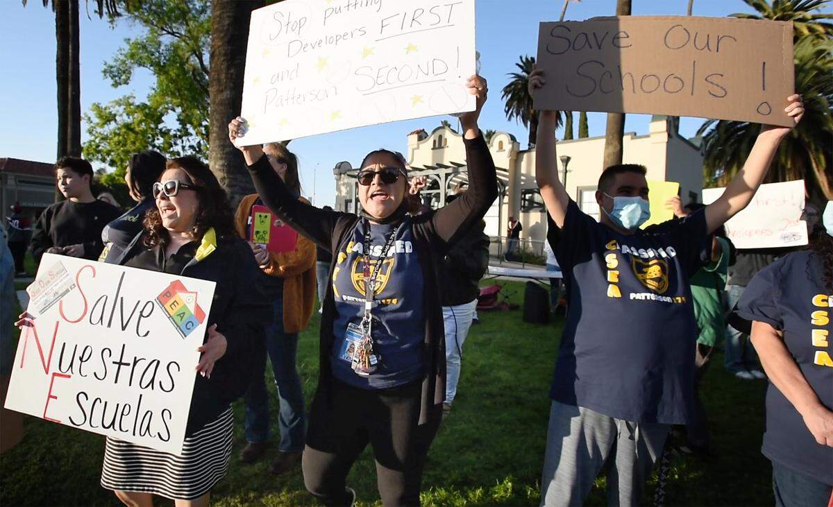 Teachers, students and parents, including Elizabeth Diaz, middle, rally outside Patterson City Hall in Patterson, Calif., on Tuesday, April 5, 2022. Educators organized the “Save Our Schools Rally” through the Patterson Education Advocacy Committee to highlight their concern that new residential developments will cause overcrowded schools and an unfair tax burden on local residents.