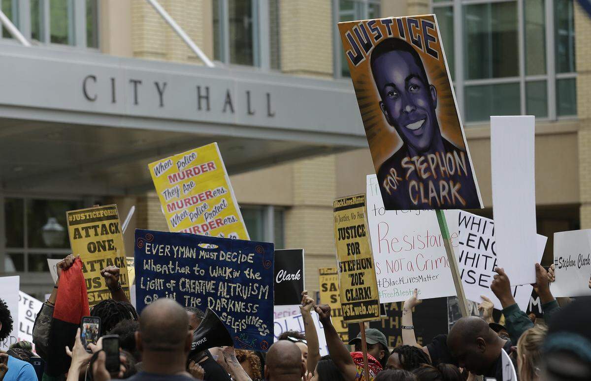 Demonstrators calling for the indictment of two Sacramento police officers who shot and killed Stephon Clark pass Sacramento City Hall as they march through downtown on  April 4, 2018. Clark, who was unarmed, was shot and killed by Sacramento police officers on March 18.