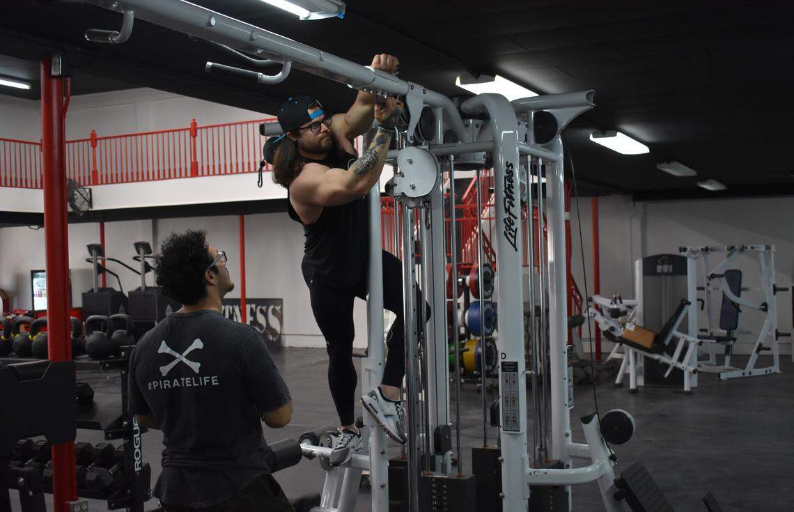 Jake Keidel works on a piece of equipment at the Tru-Fitness personal training studio, 1511 J St., in downtown Modesto on Wednesday, March 4, 2020. With him is Mario Alcantar.