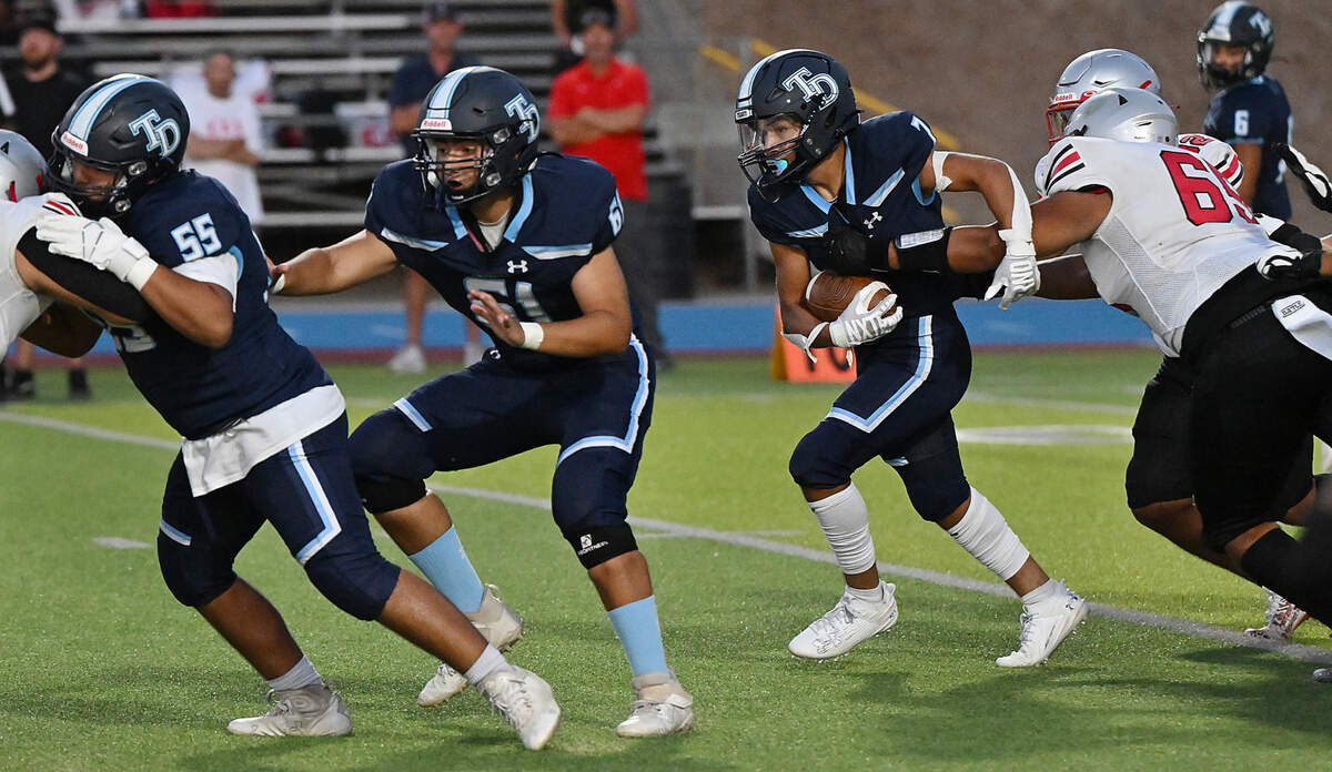 Downey’s Elijah Tamayo slips a tackle on a run during the game with Lincoln at Downey High School in Modesto, Calif., Friday, August 18, 2023.
