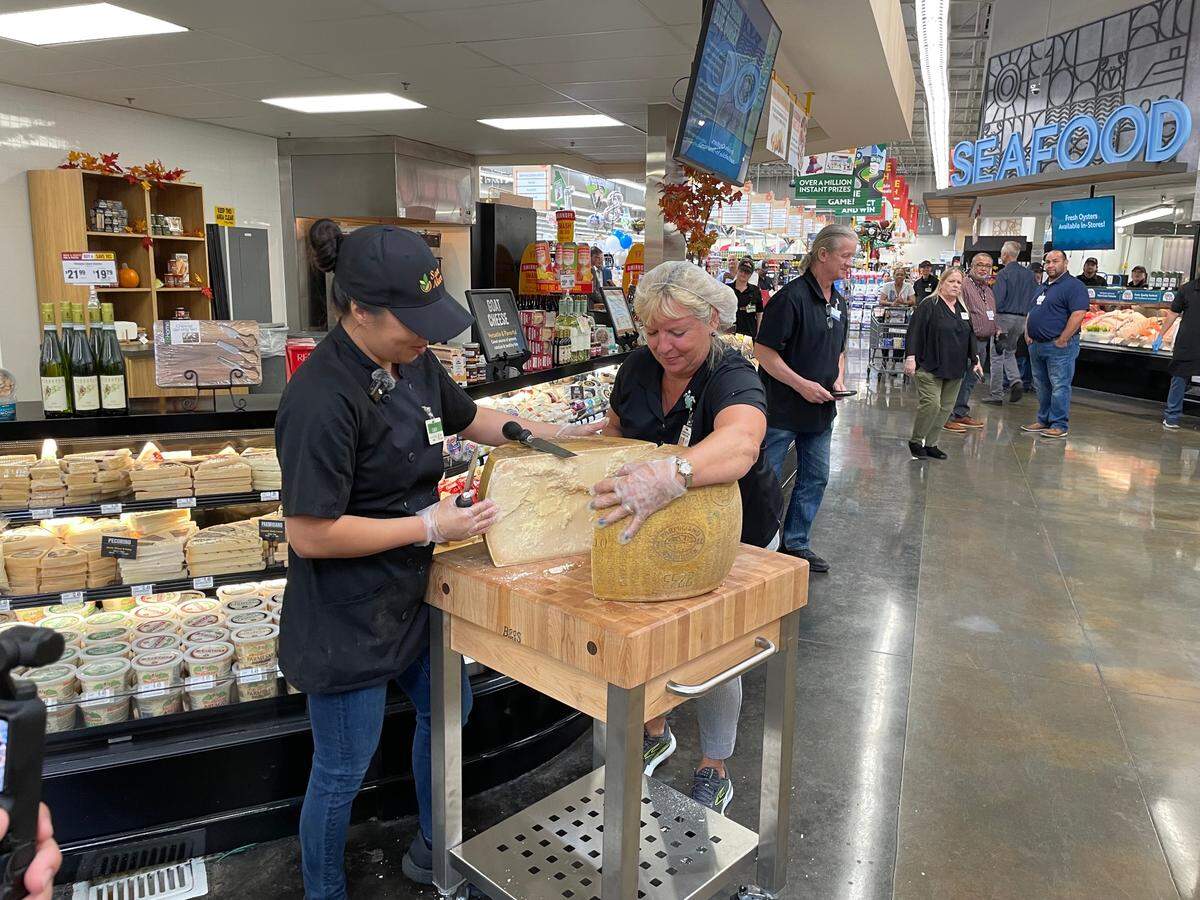 Save Mart deli employees cut into a Parmesan Cheese wheel at the grand re-opening of the store in Riverbank on Thursday, Sept. 12.