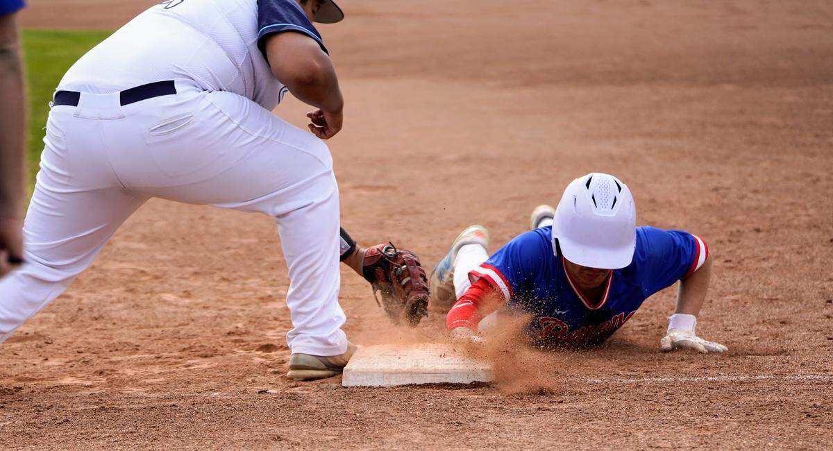 Beyer’s Izaiah Ishihara dives back to first during the championship game of the Windemuth Tournament against Downey at Modesto High School on Thursday, April 24, 2025.